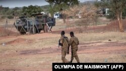 Maafisa wa Jeshi la Burkina Faso wakilinda doria karibu na magari ya kijeshi ya Ufaransa yaliyo egeshwa Kaya, mji mkuu wa Burkina Faso baada ya waandamanaji kuzuia magari hayo yasipite katika eneo hilo yakielekea Niger, Novemba 20, 2021. (Photo by OLYMPIA DE MAISMONT / AFP)