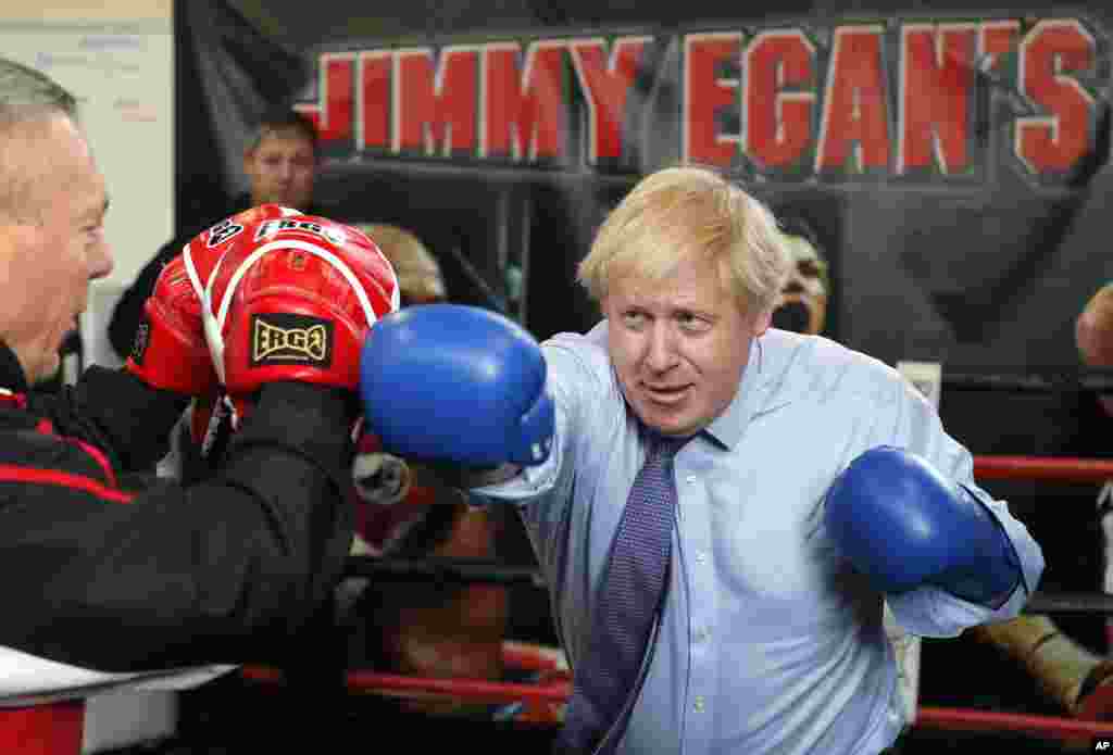 Britain's Prime Minister Boris Johnson works out with trainer Steve Egan during a stop in his General Election Campaign trail at Jimmy Egan's Boxing Academy in Manchester, England.