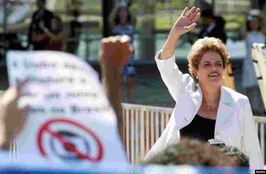 A Presidente suspensa, Dilma Rousseff, acena aos seus apoiantes à saída do Palácio do Planalto em Brasília.