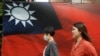 人们从台北街头的台湾旗帜旁走过。（2020年8月10日）
