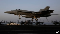 Un avión de combate de Estados Unidos aterriza en la cubierta del portaviones USS George H.W. Bush de regreso de Siria.