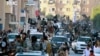 FILE - Fighters from the Islamic State group parade in Raqqa, north Syria, earlier this year. 