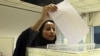 A Saudi woman casts her ballot at a polling center during municipal elections in Riyadh, Saudi Arabia, Dec. 12, 2015.