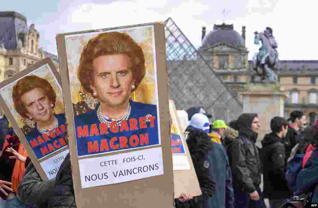 Protesters hold placards reading "Maragaret Macron, this time we will win" under a photomontage of late British Prime Minister Margaret Thatcher and French President Emmanuel Macron as they demonstrate in front of the Louvre Museum in Paris as part of a multi-sector strike against the French government's pensions overhaul.