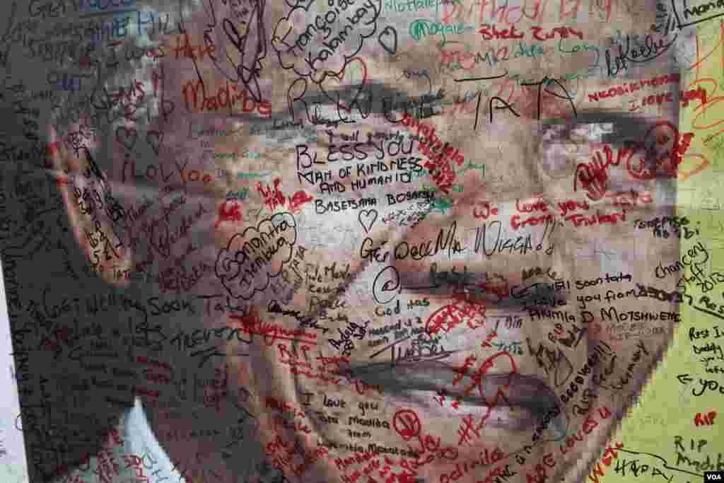 Mensagens de agradecimento e tristeza são escritas num poster gigante à porta da casa de Mandela em Soweto, África do Sul. (Hannah McNeish para VOA)