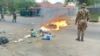 Um militar olha para chamas numa rua de Maputo, capital moçambicana que acordou sob mais um dia de protestos, convocado por Venâncio Mondlane a 7 de novembro.