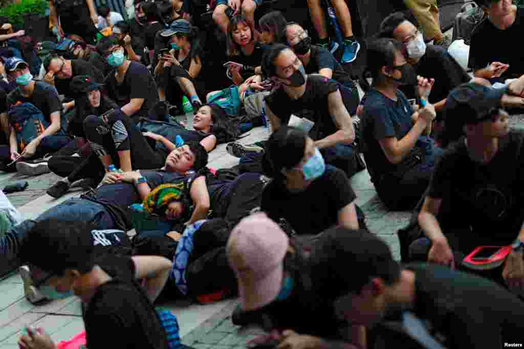 示威者2019年6月21日在香港舉行的示威活動中坐著或躺在地上,他們要求香港領導人下台並撤回引渡法案。