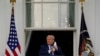 FILE - U.S. President Donald Trump throws a face masks into the crowd as he arrives to hold a campaign rally at John Murtha Johnstown-Cambria County Airport in Johnstown, Pennsylvania, Oct. 13, 2020. 