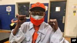 Charles Robbins celebrates getting his second shot of coronavirus vaccine at Surry County High School in Dendron, Va., on Feb. 27, 2021.