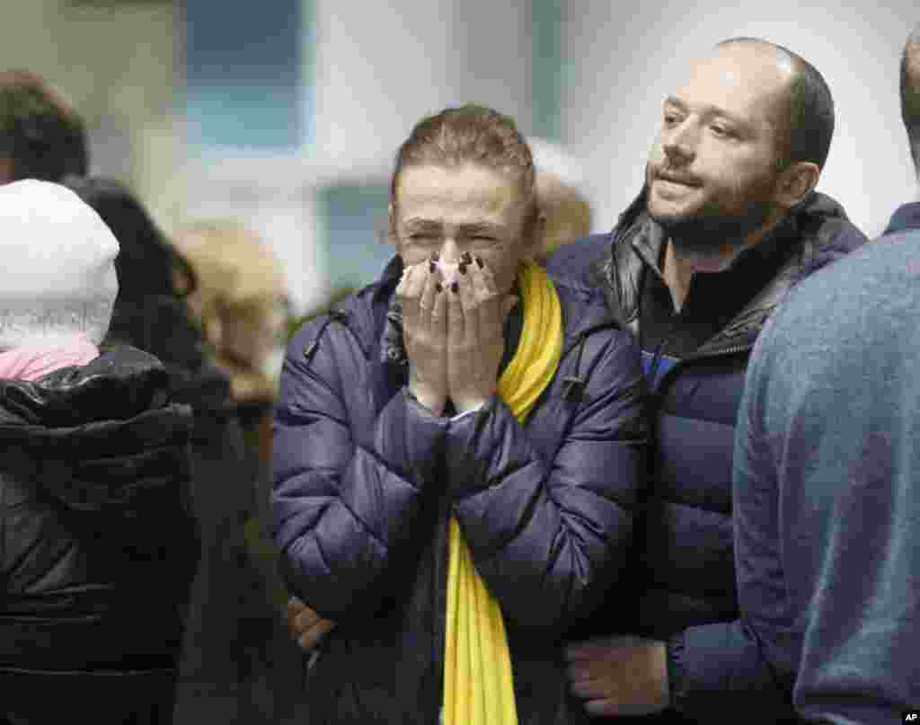 A stewardess with Ukrainian air-line reacts, near to coffins of the flight crew members of the Boeing 737-800 plane that crashed on the outskirts of Tehran, during a memorial service at Borispil international airport outside Kyiv, Ukraine.