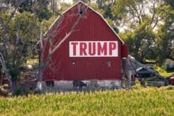 FILE - Corn grows in front of a barn displaying a large Trump sign in rural Ashland, Nebraska, July 24, 2018.