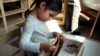 In this Oct. 12, 2017 photo a child in a combined pre-kindergarten and kindergarten Wampanoag language immersion class removes kernels from an ear of corn at the Wampanoag Tribe Community and Government Center, in Mashpee, Mass. 