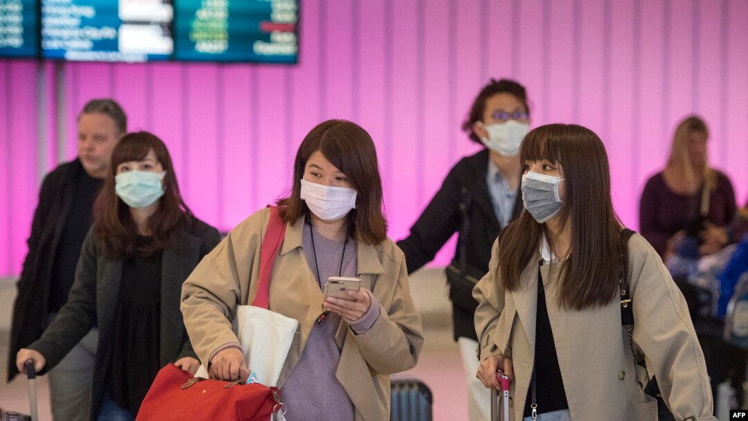 乘客在抵達加州洛杉磯國際機場時戴上防護口罩，以防冠狀病毒的傳播（2020年1月22日）。