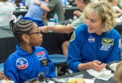 in this July 13, 2018 file photo, NASA astronaut Dottie Metcalf-Lindenburger talks with Space Camp camper Bria Jackson, of Atlanta, before giving a speech at the U.S. Space &amp; Rocket Center in Huntsville, Ala. Space Camp.