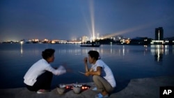 지난해 7월 북한 원산 앞 장덕도에서 주민들이 화덕에 해산물을 굽고 있다. 북한은 지난해 원산을 세계적인 휴양지로 개발하겠다며 해외 투자설명회를 열기도 했다. (자료사진)