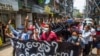 Anti-coup protesters hold a banner that reads "What are these? We are Yangon residents!" as they march during a demonstration in Yangon, Myanmar, April 27, 2021. 