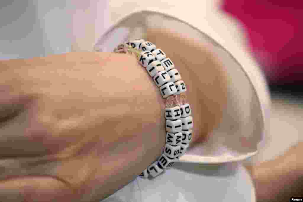 "Jane Doe 15," a 31-year-old unidentified woman, who accuses the late financier Jeffrey Epstein of sexually abusing her when she was a teenager, wears a bracelet that reads "Epstein didn't kill himself" as she speaks at a news conference in Los Angeles, California, Nov. 18, 2019.