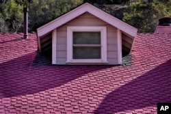 Fire retardant from crews battling the Palisades Fire coats the roof of a home in Mandeville Canyon on Monday, Jan. 13, 2025, in Los Angeles.