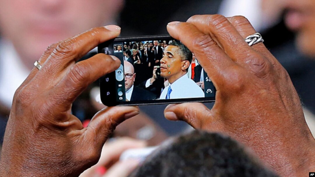 Uno de los asistentes al discurso del presidente Barack Obama en Phoenix, capta una imagen del mandatario tras el evento.