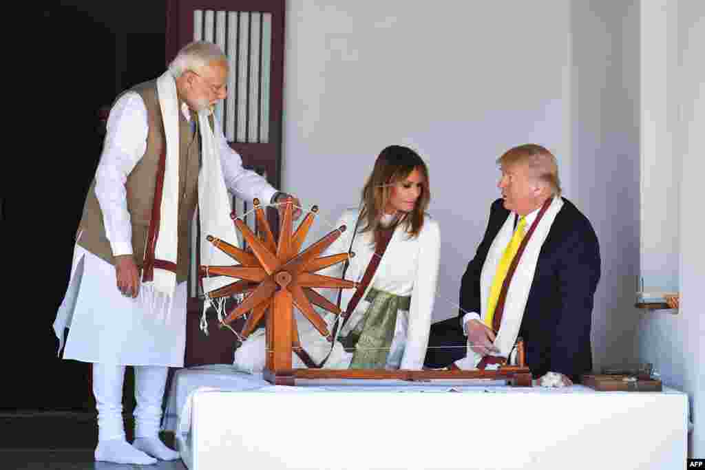 U.S. President Donald Trump and First Lady Melania Trump listen to India's Prime Minister Narendra Modi (L) as they sit next to a charkha, or spinning wheel, during their visit at Gandhi Ashram in Ahmedabad.