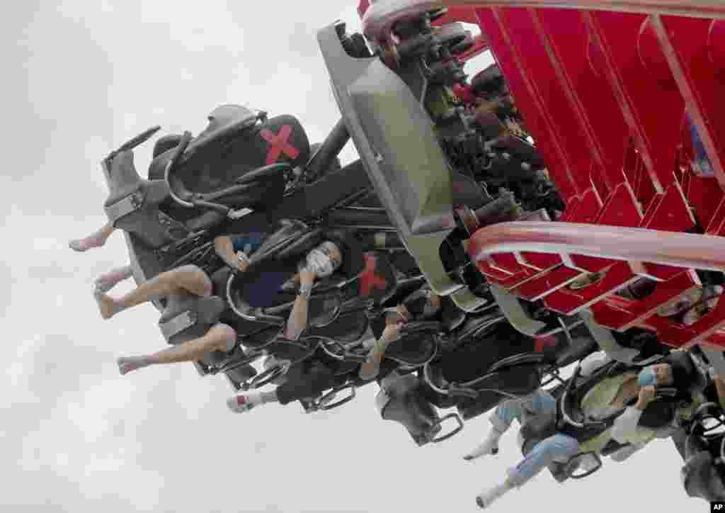 Visitors wear their face masks ride the "Vortex" roller coaster at the recently reopened Siam Amazing Park in in Bangkok, Thailand
