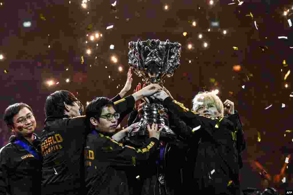 Chinese team FPX celebrates with the trophy after winning the "League of Legends" videogame world championship final against European team G2 at the AccorHotels Arena in Paris, France.