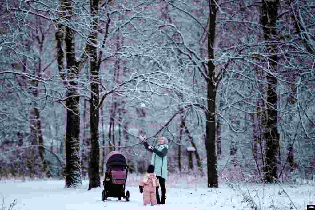A woman plays with a child in Moscow's Tushino park after a snowfall.